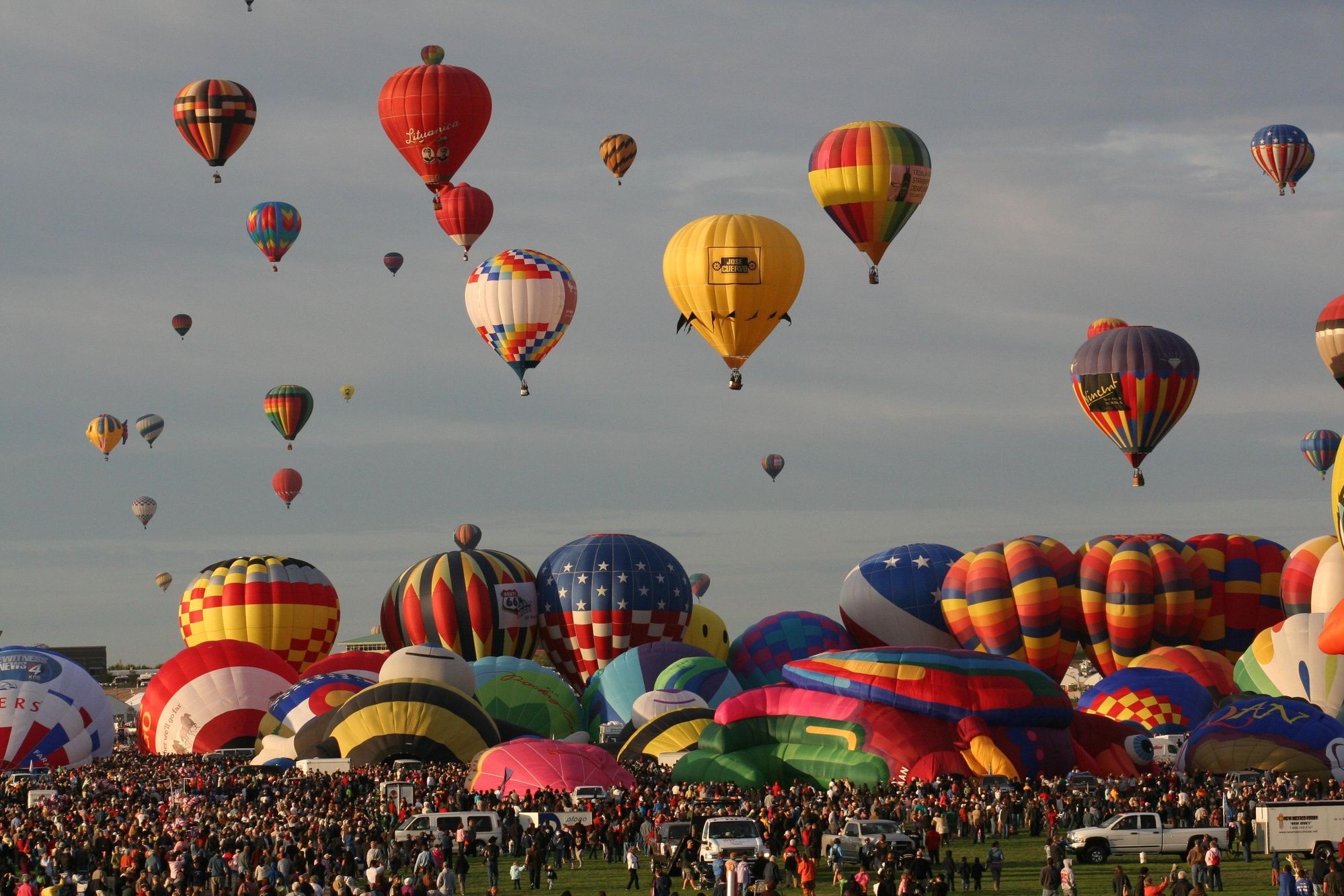 Balloon envelopes inflating and launching over the crowd at the 2010 Albuquerque International Balloon Fiesta; historical edition, not the 2027 event.