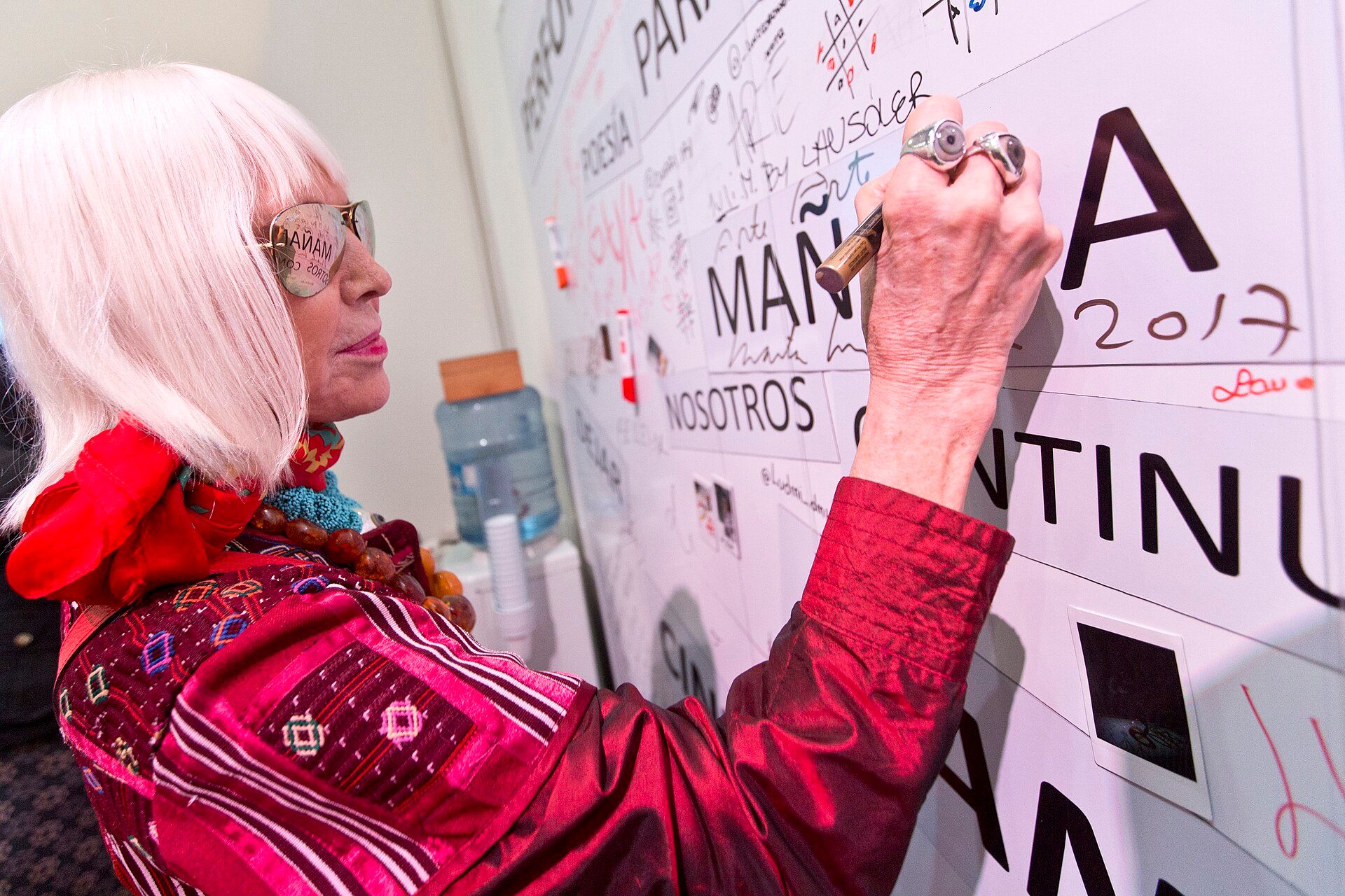 Artist Marta Minujín writing on an interactive work at arteba