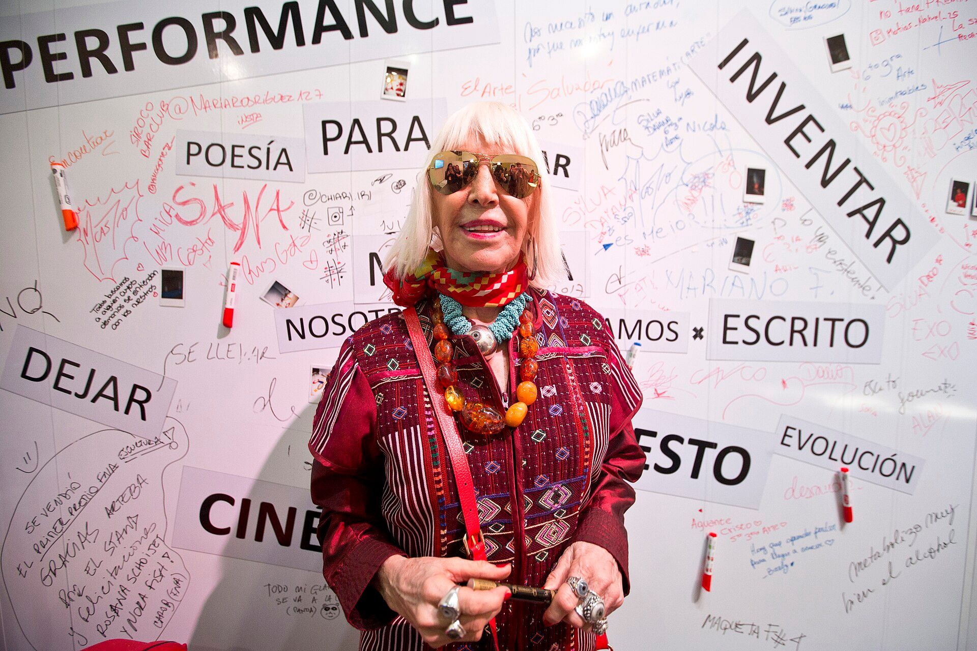Marta Minujín standing before an interactive text installation at arteba