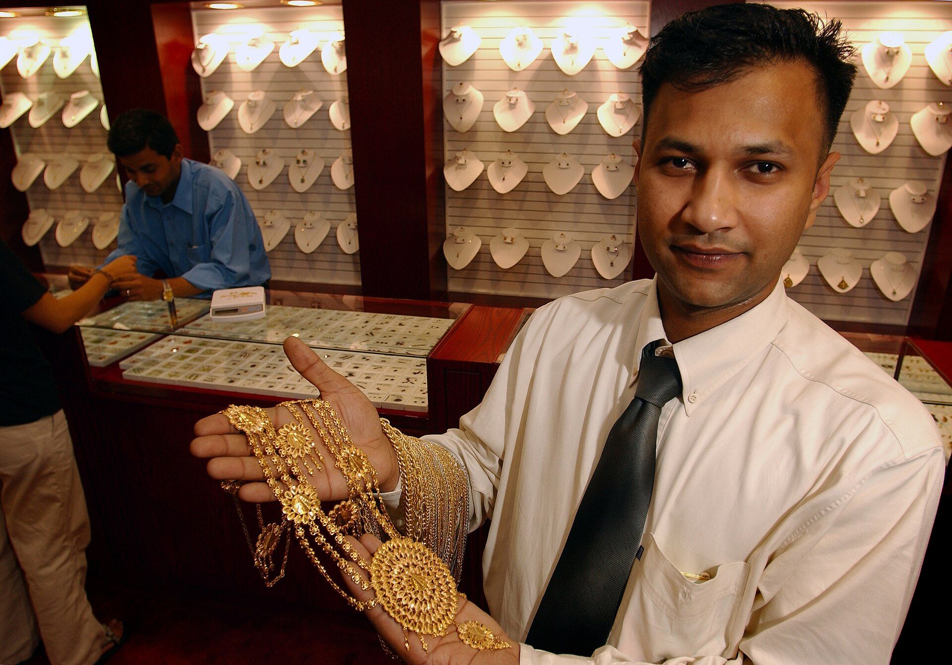 A Bahrain jeweler presenting a detailed gold necklace