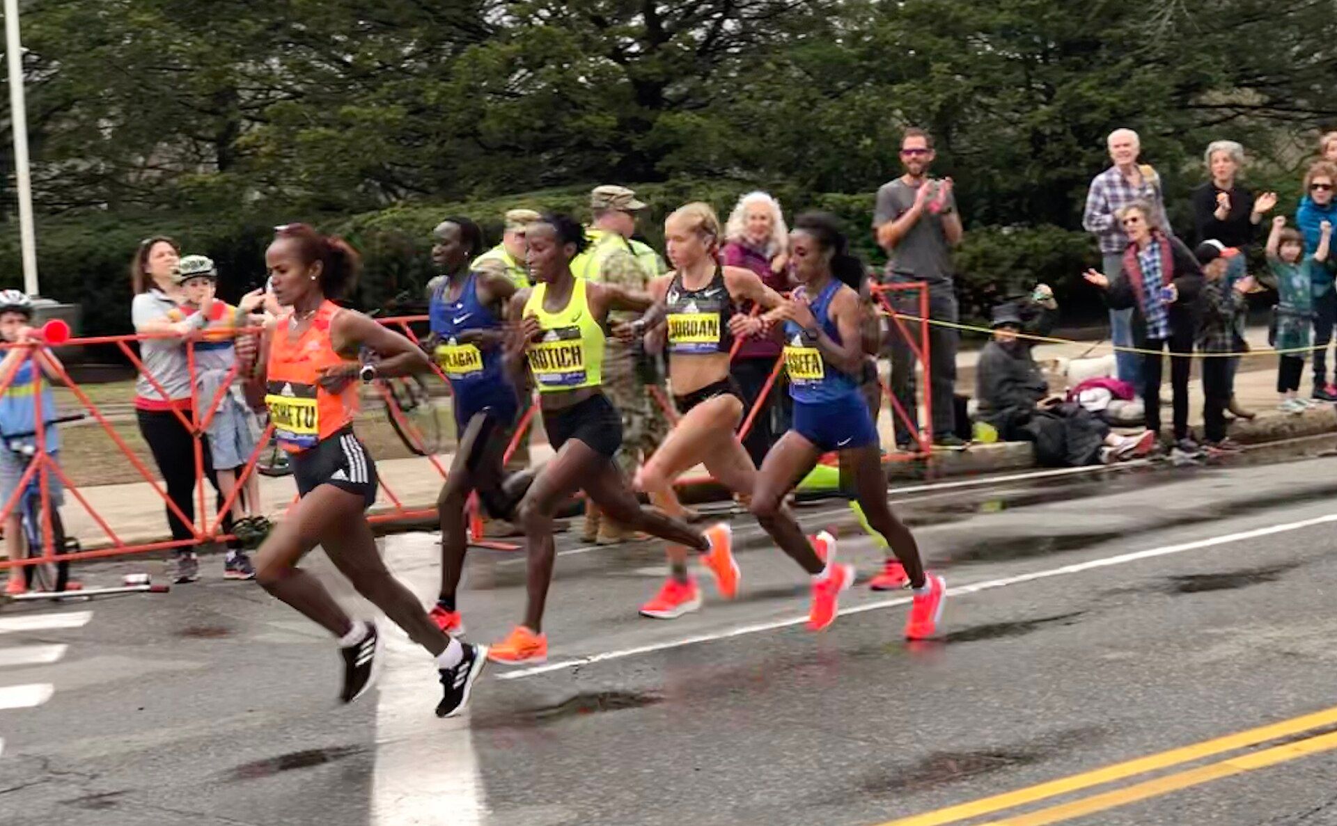 The women’s field racing past Boston Marathon spectators