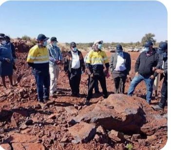 Botswana mining workers and officials examining mineral-bearing rock