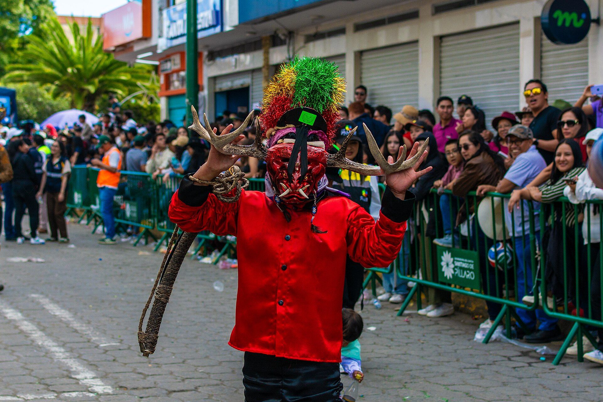 A Diablada Pillareña dancer adjusting a handmade antlered mask