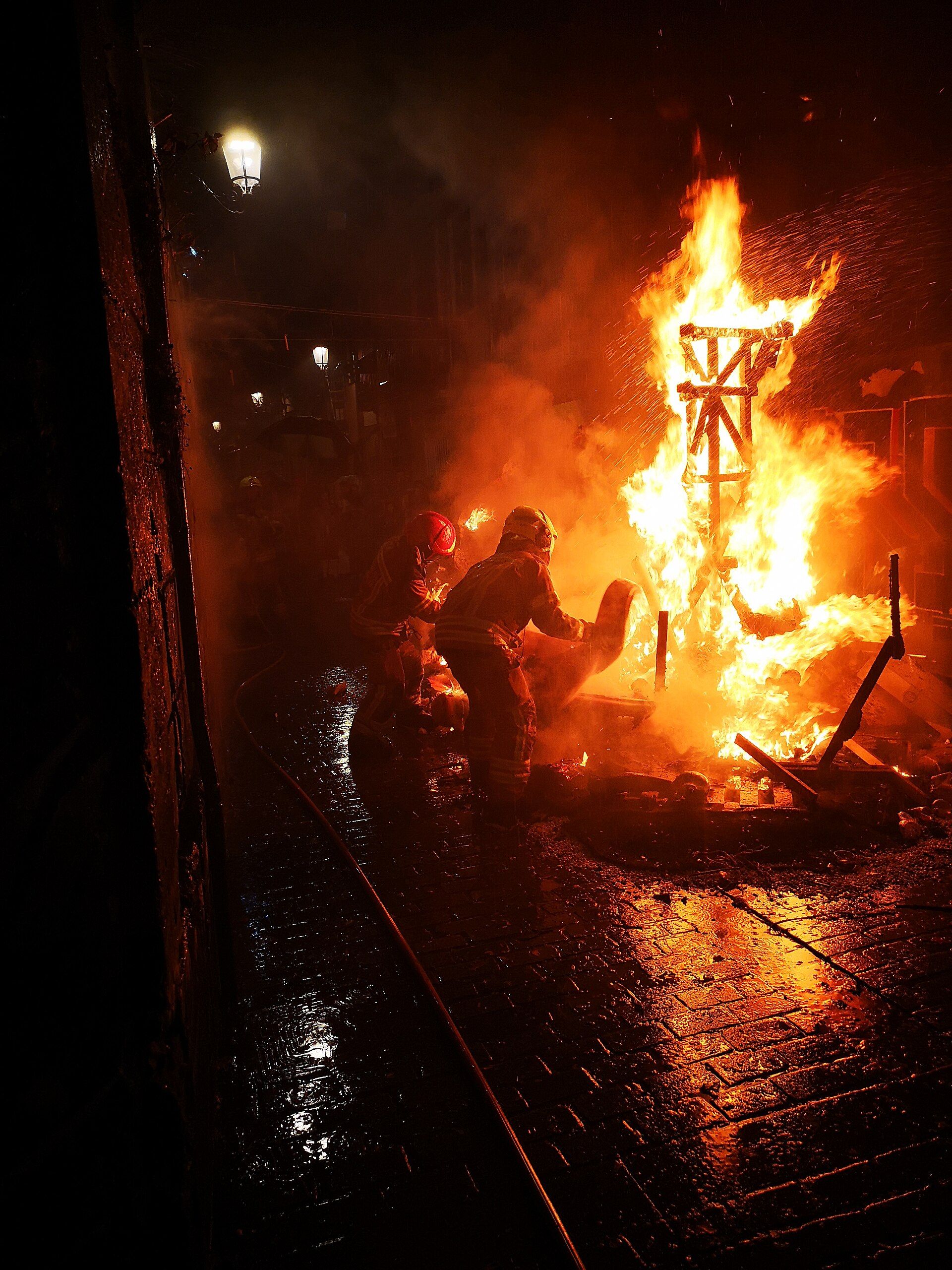 Firefighters managing the burning of a falla in Valencia