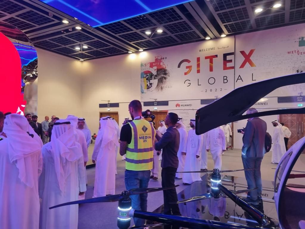 Visitors exploring a technology demonstration on the GITEX Global floor