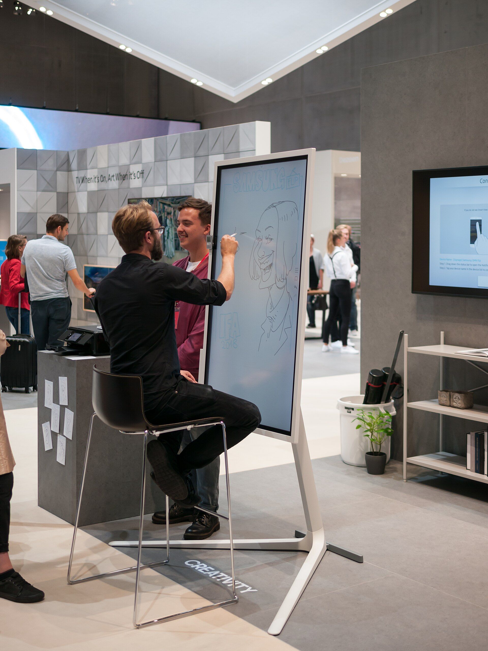 A visitor interacting with a large digital display at IFA Berlin