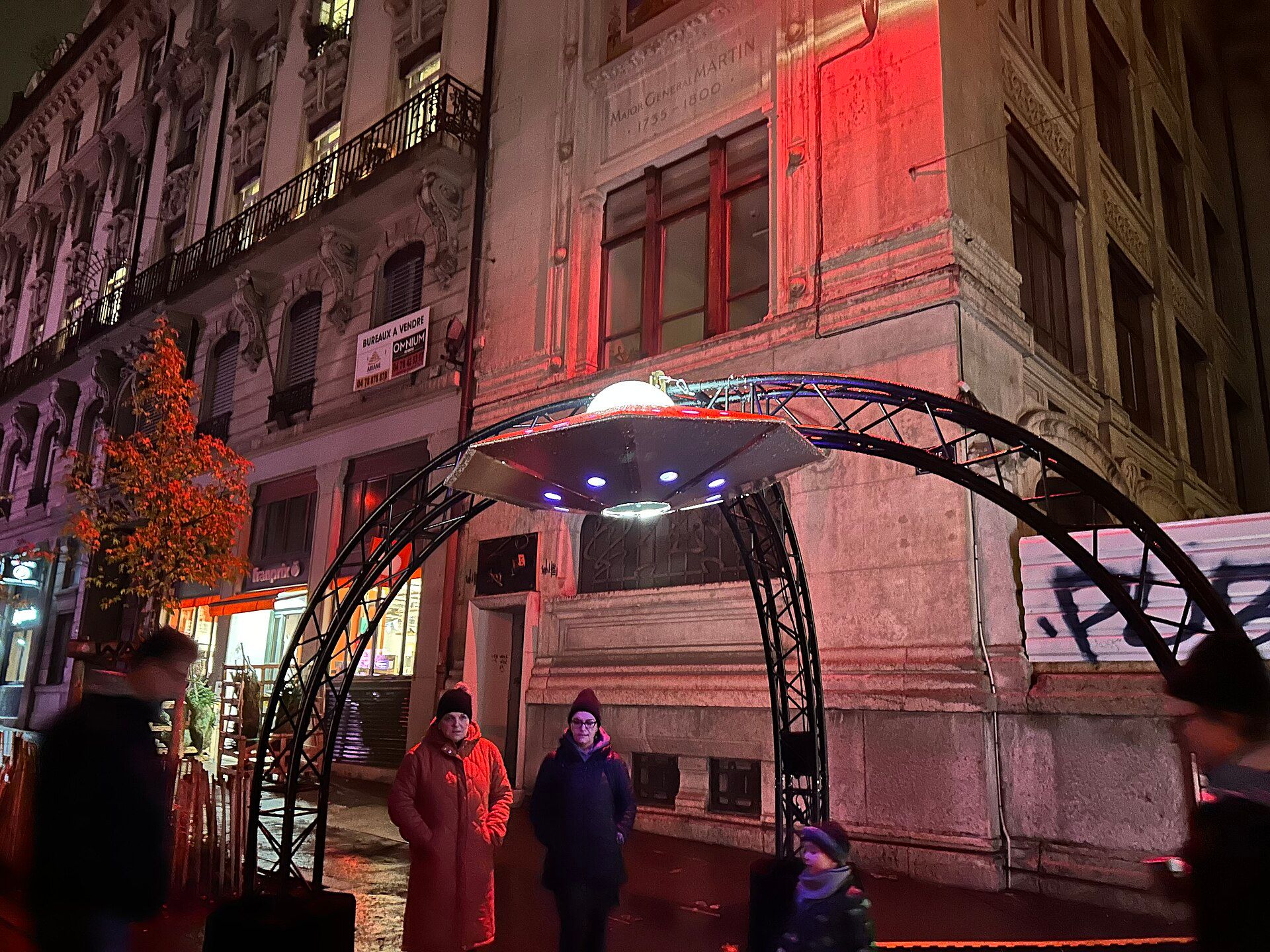 Large illuminated artwork reflected in water during Lyon's Fête des Lumières