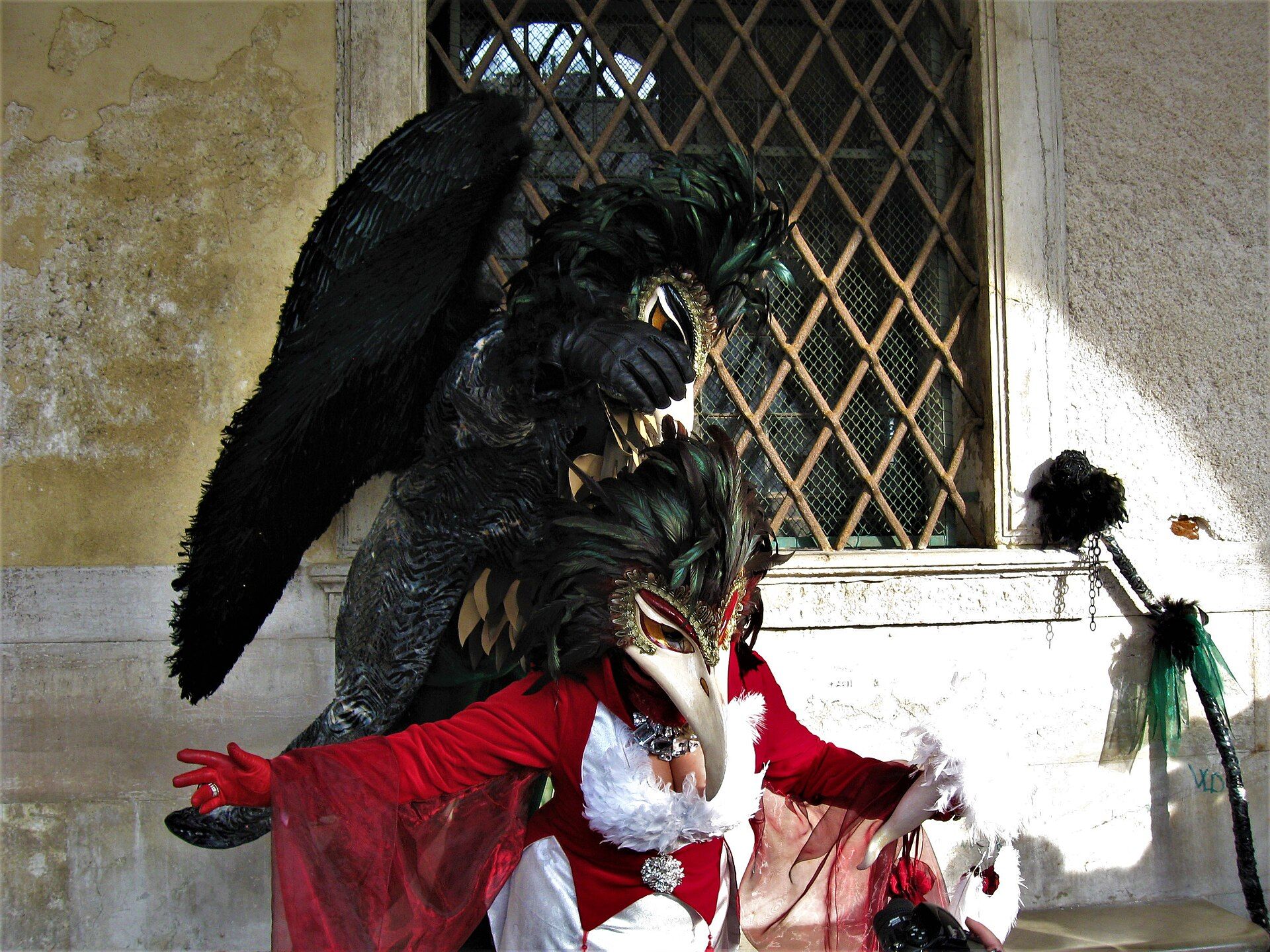 Masked Carnival participants posing beside the Venetian lagoon