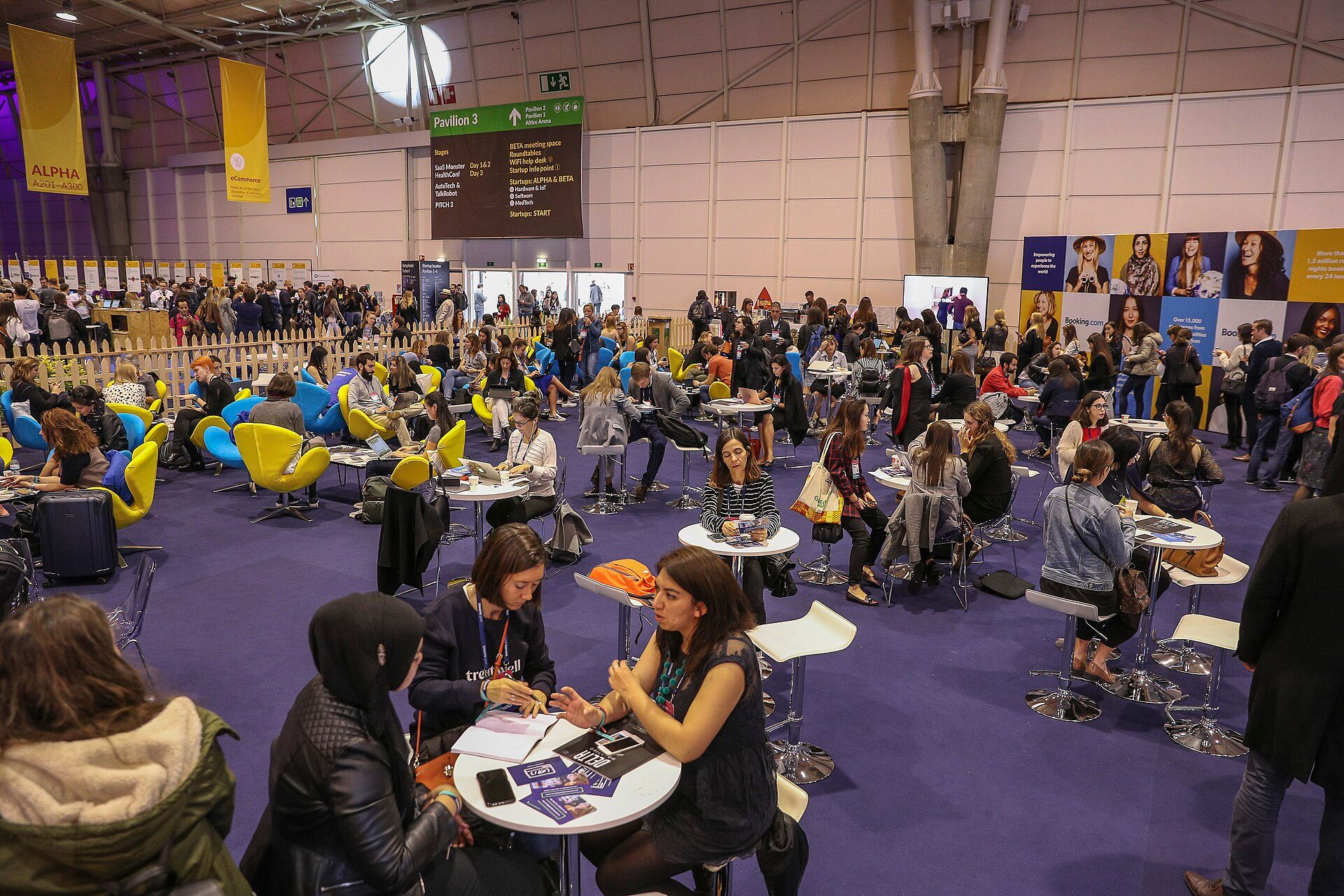 Attendees working and meeting across the Web Summit exhibition floor